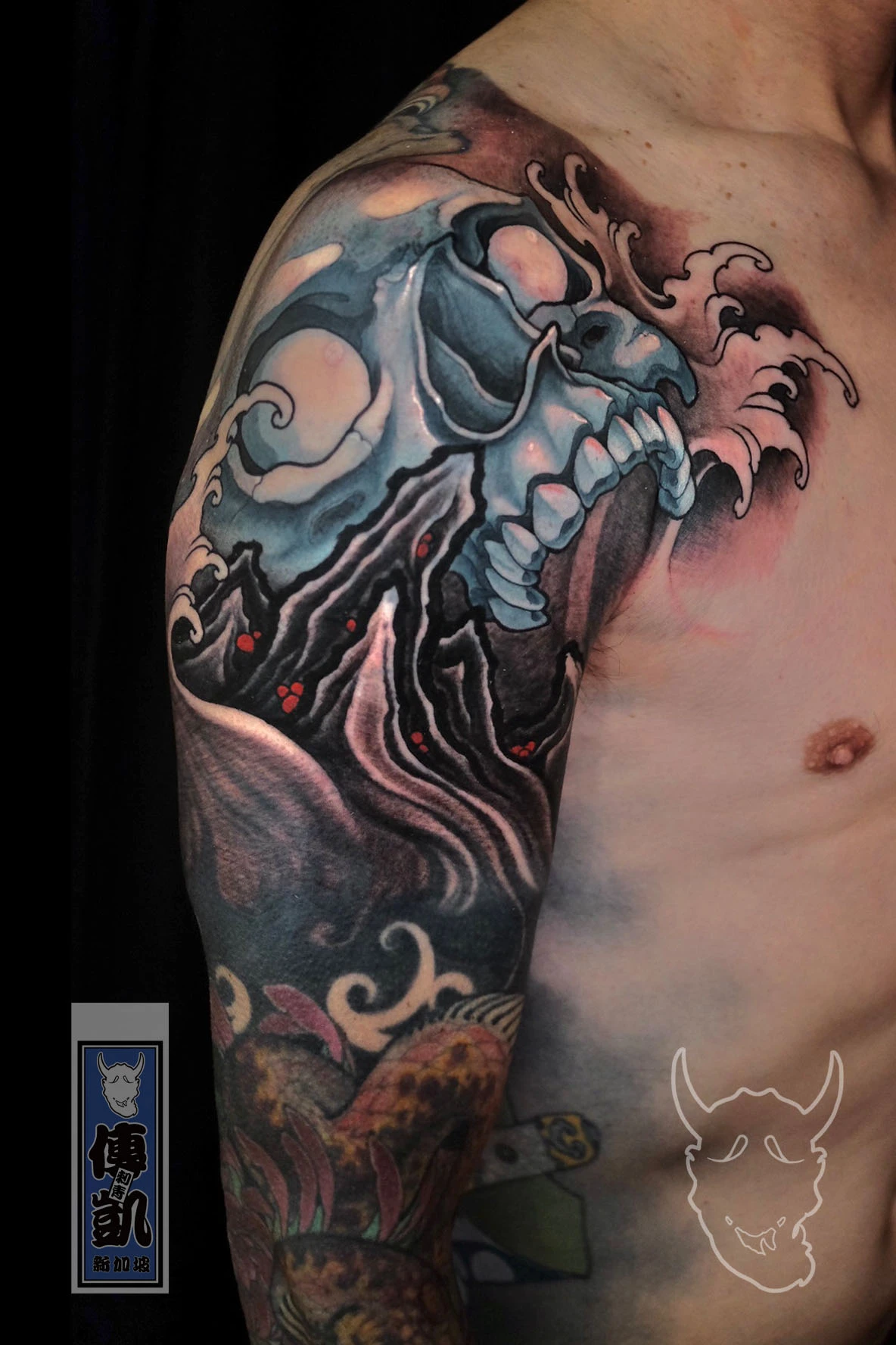 Japanese skull arm sleeve tattoo with wave and wind motifs, representing the cycle of life and death in traditional Irezumi art.