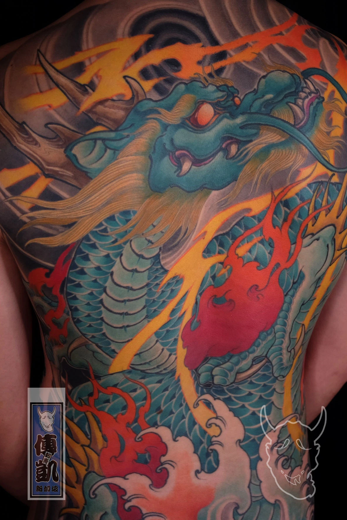 Japanese full back tattoo of the Azure Dragon with fire and wave motifs, representing protection, courage, and natural harmony in traditional Irezumi art.