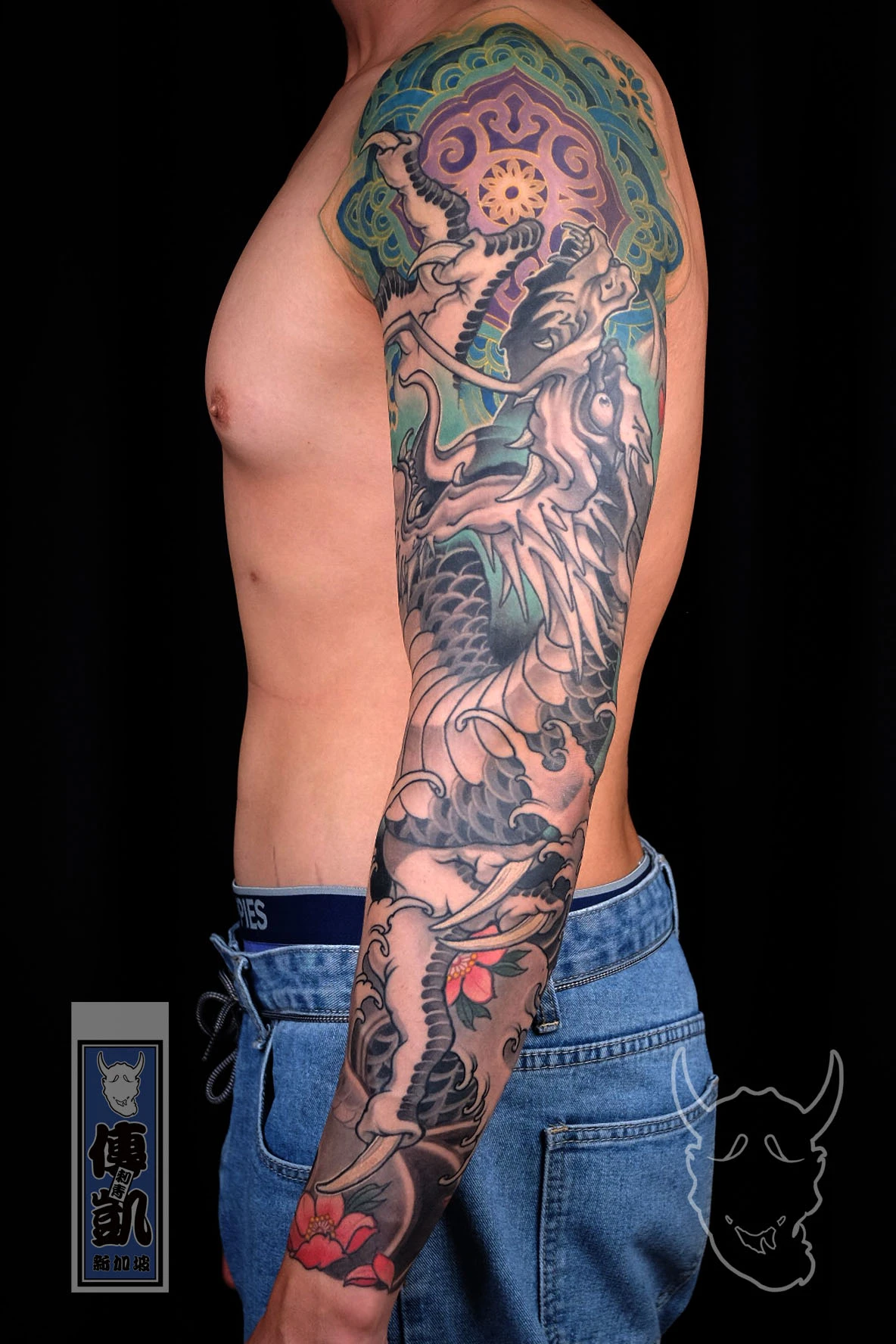 Blue Japanese dragon arm sleeve tattoo inspired by Seiryū, featuring detailed scales and wave patterns symbolizing strength, wisdom, and protection.