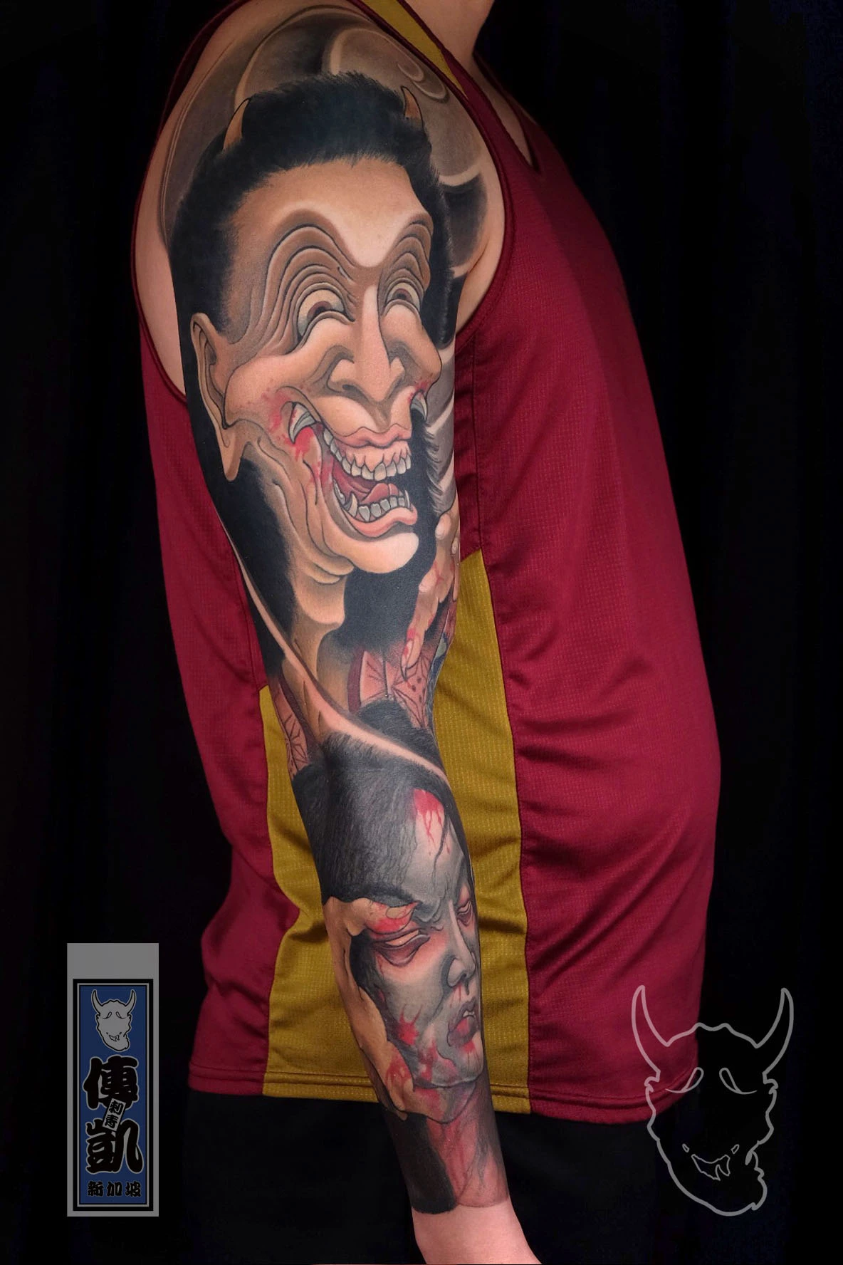 Japanese Warai Hannya arm tattoo with surreal laughing mask design, symbolizing emotional conflict, illusion, and transformation in modern Irezumi art.