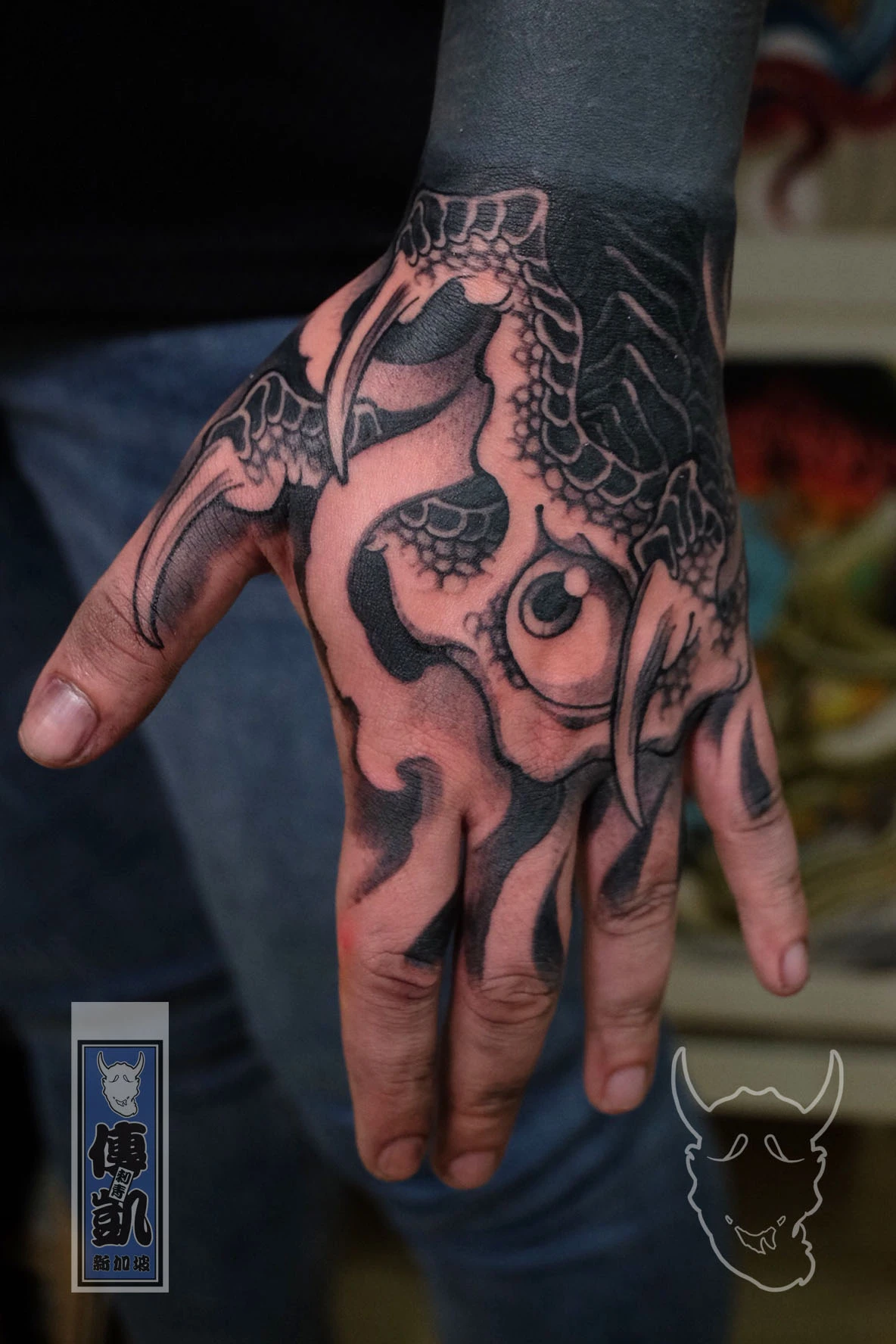 Black and grey Japanese tattoo of a dragon claw and scales on the hand, featuring detailed shading and bold contrast, symbolizing power and protection. Created by CK Tattoo Singapore.