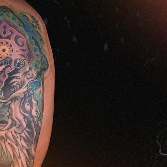 Blue Japanese dragon arm sleeve tattoo inspired by Seiryū, featuring detailed scales and wave patterns symbolizing strength, wisdom, and protection.