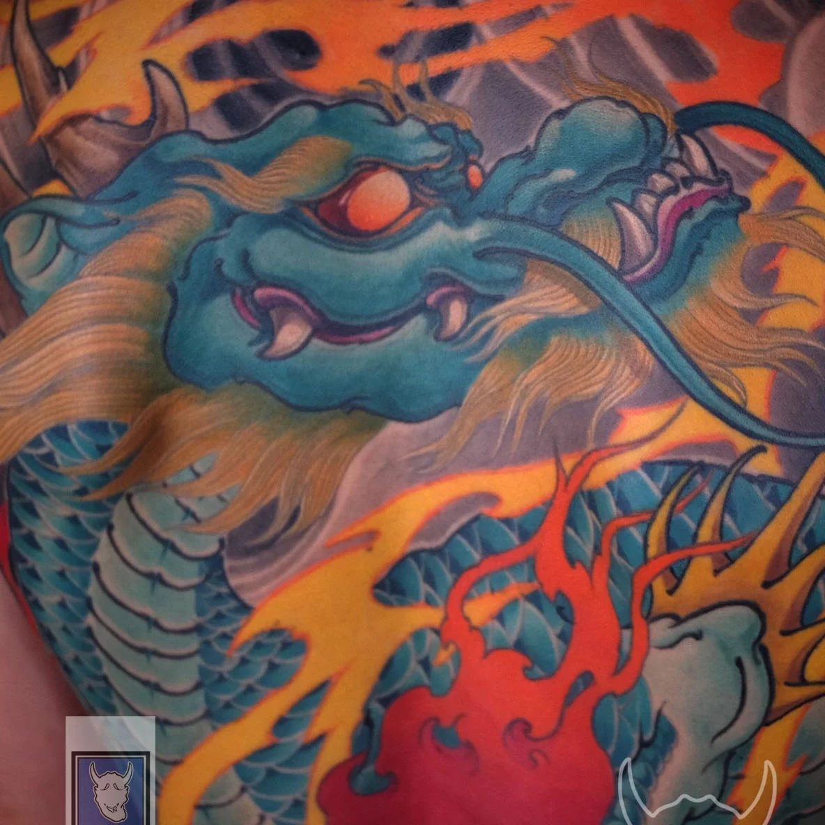 Japanese full back tattoo of the Azure Dragon with fire and wave motifs, representing protection, courage, and natural harmony in traditional Irezumi art.