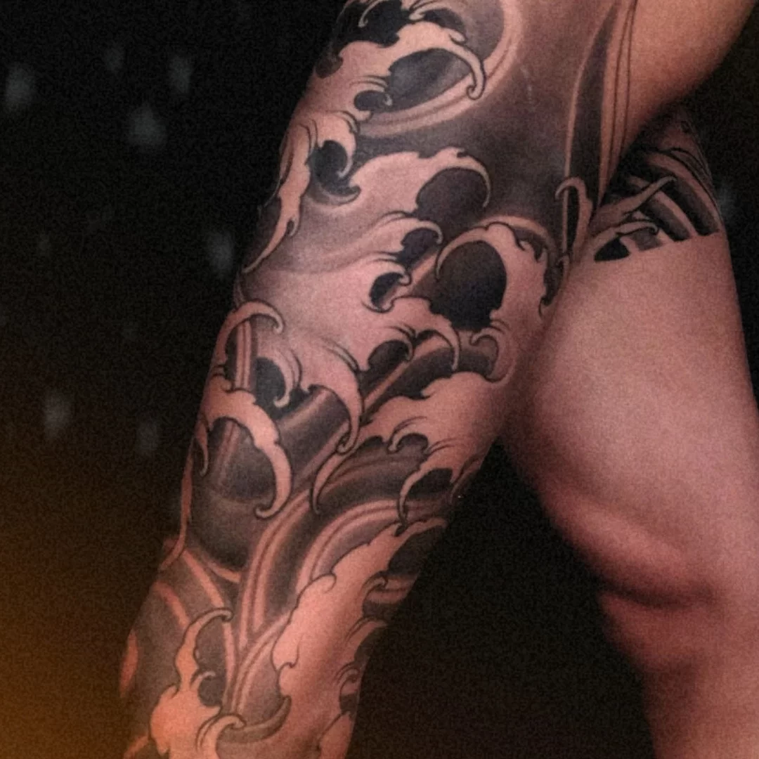 New Traditional Japanese full leg tattoo with black and grey waves, symbolizing strength and fluid energy. CK Tattoo Singapore.