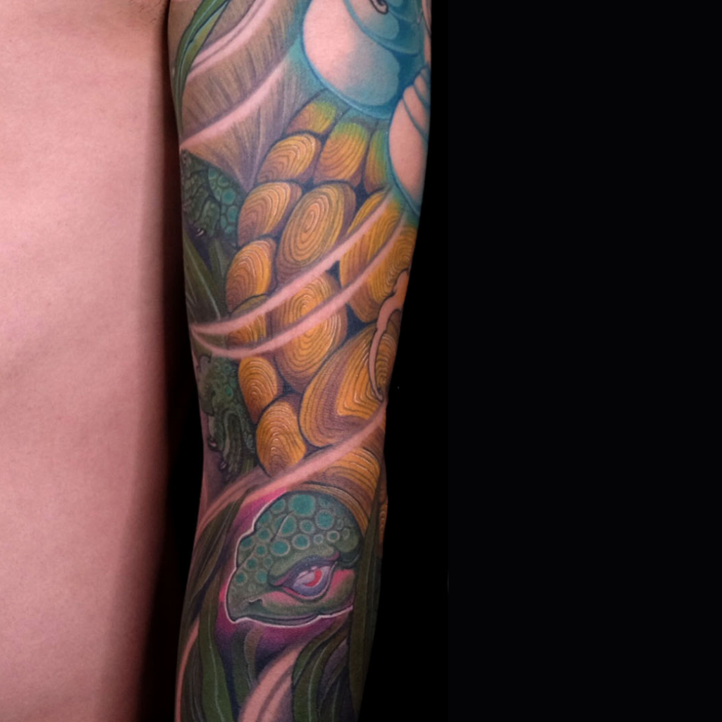 Japanese minogame ancient turtle sleeve tattoo with flowing seaweed tail and waves by CK Tattoo Singapore