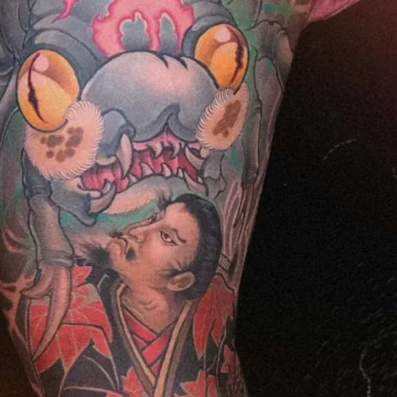 New Traditional Japanese leg tattoo of Minamoto no Yorimitsu fighting a giant creature, featuring vibrant red and green tones with dynamic wave and kimono patterns in full leg composition.